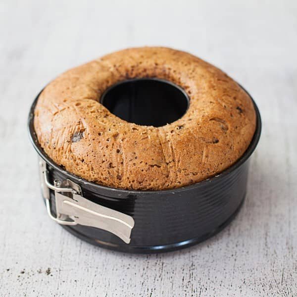 Golden fruit ring cake baked in the 2-in-1 Springform Pan and still sitting in the tin, with the springform clasp visible on the side