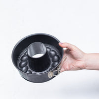 Hand holding the assembled 2-in-1 Springform Pan seen from above, with the fluted ring insert in place