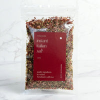 Alyce's Instant Italian Salt 100g bag with red label, the pink salt, tomato and herb blend visible through the clear packet