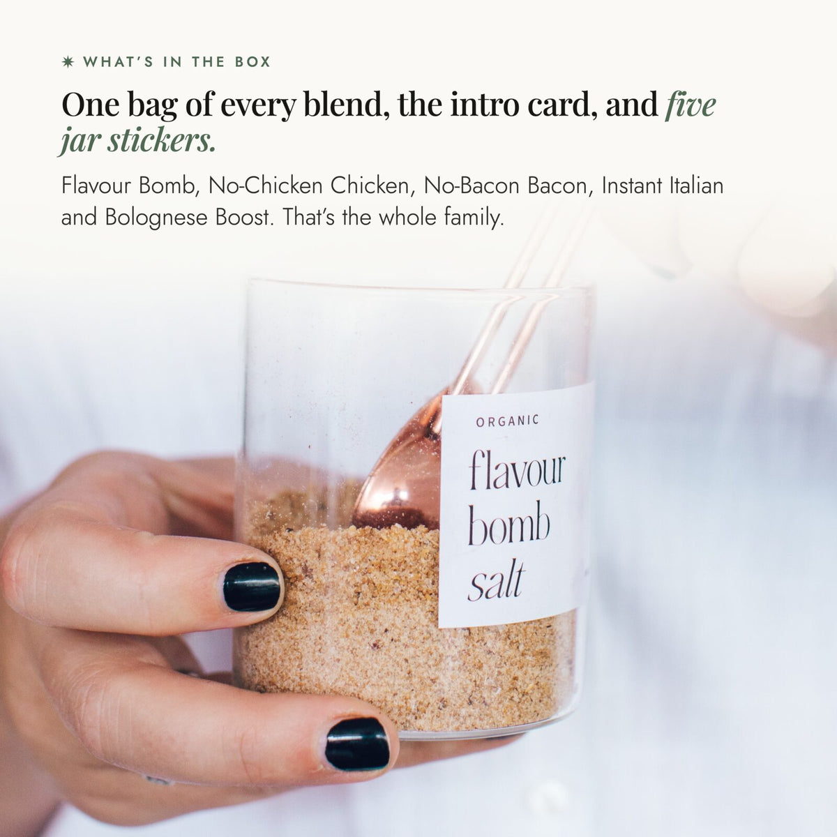 Hand holding a glass jar of Flavour Bomb Salt with a copper spoon; Alyce's Flavour Bombs Starter Pack contains one bag of every blend, the intro card and five jar stickers