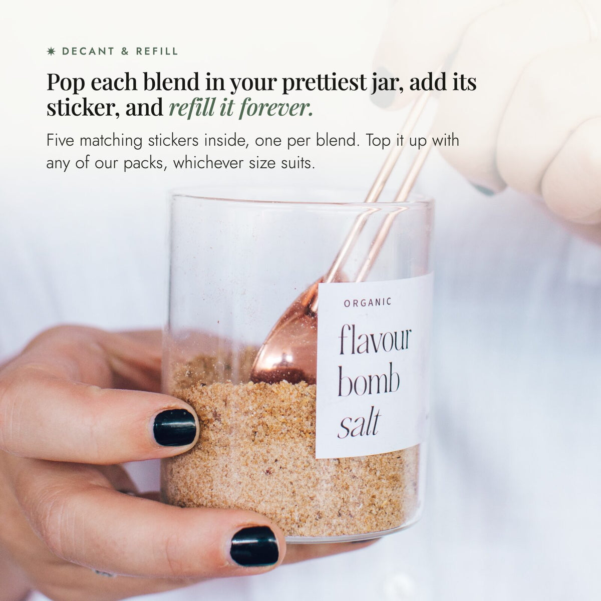Hand spooning Flavour Bomb Salt from a labelled glass jar; decant each Alyce's Flavour Bombs Starter Pack blend into a jar, add its sticker and refill it forever