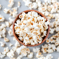 Wooden bowl of freshly popped popcorn seasoned with No-Chicken Chicken Salt
