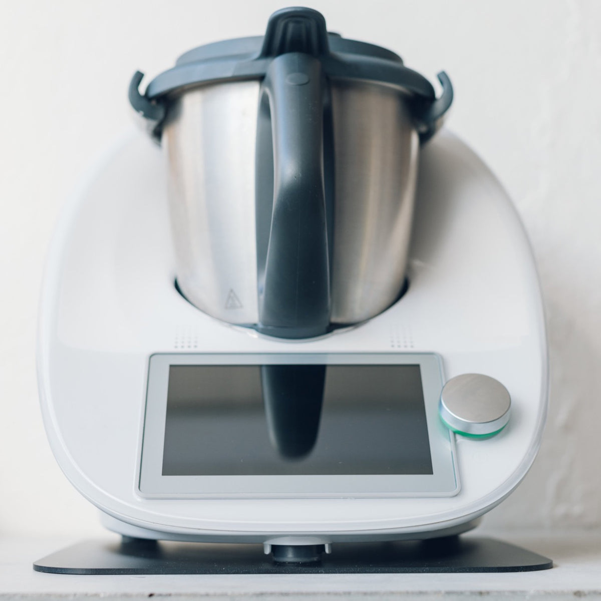 Thermomix sitting on the Appliance Mat, the thin mat visible under the base so the machine can slide instead of being lifted