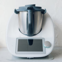 Thermomix on the Appliance Mat with the mat edge just visible beyond the machine's feet