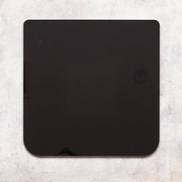 The Appliance Mat on its own, a thin square black mat with a small notch on one edge