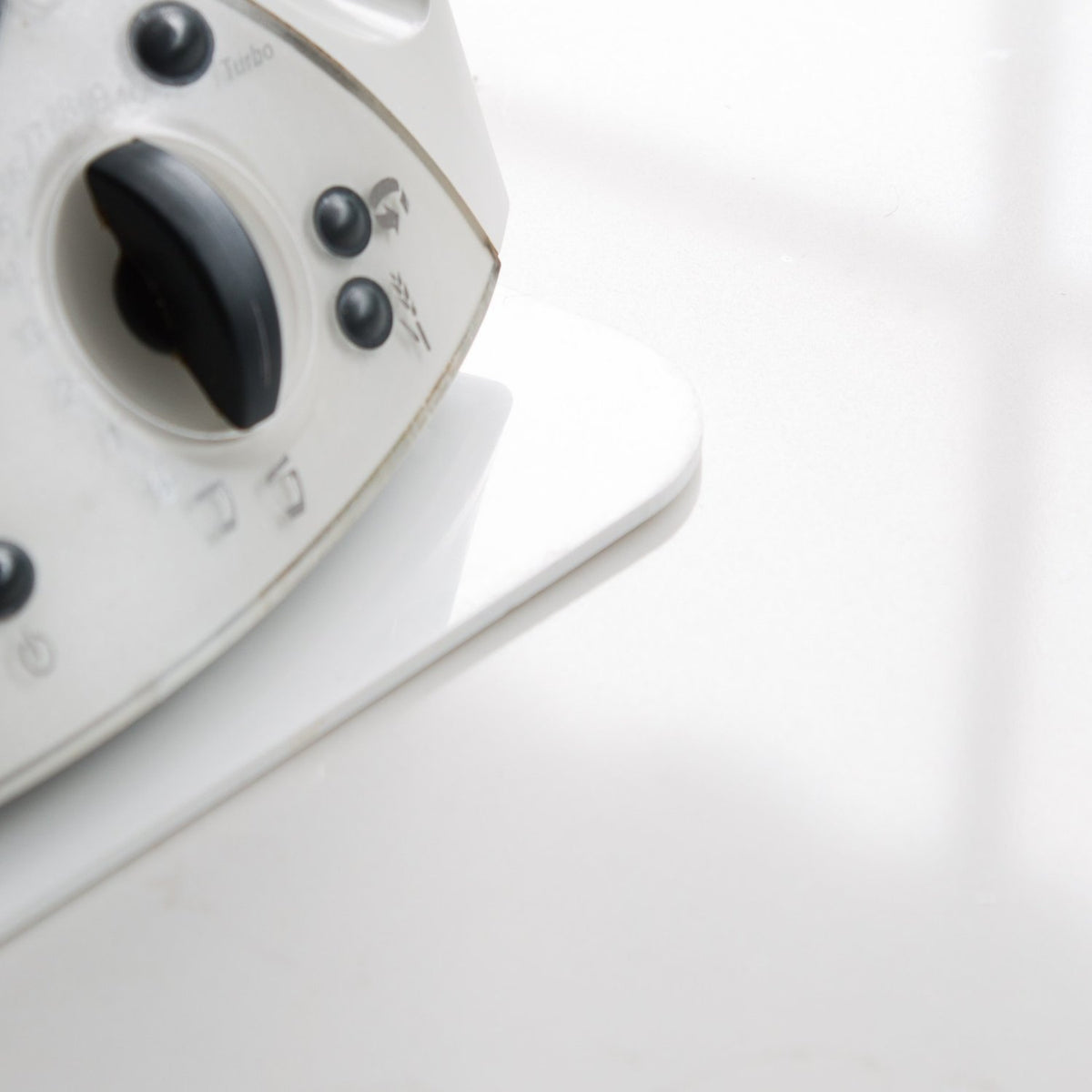 Older Thermomix TM31 sitting on a white Appliance Mat, shown from the side