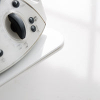 Older Thermomix TM31 sitting on a white Appliance Mat, shown from the side