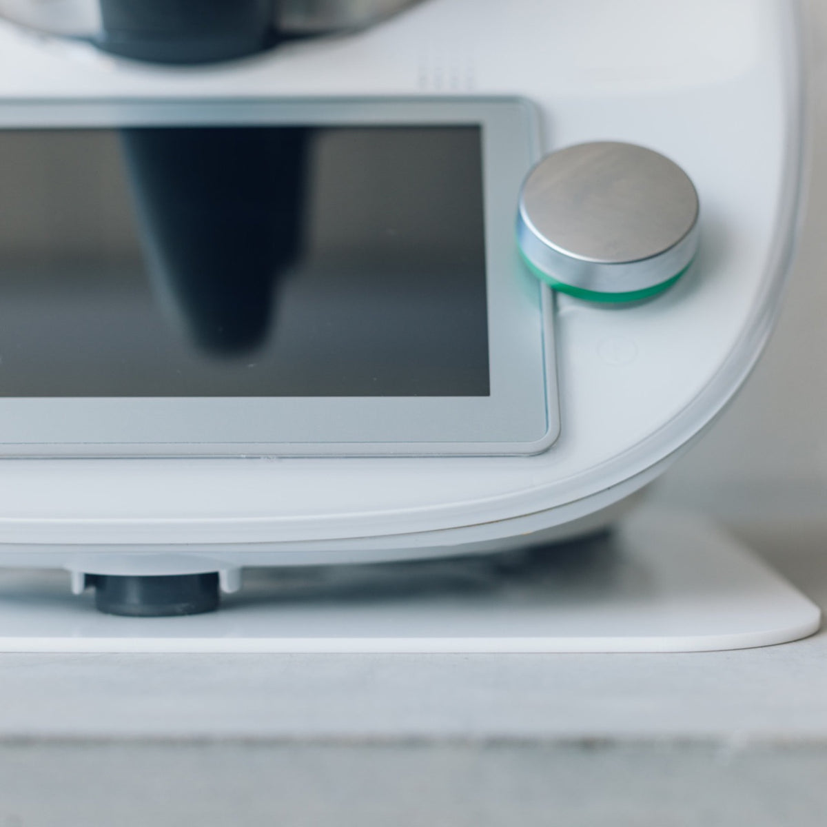 Close-up of a Thermomix base on a white Appliance Mat, showing the machine's feet resting on the mat
