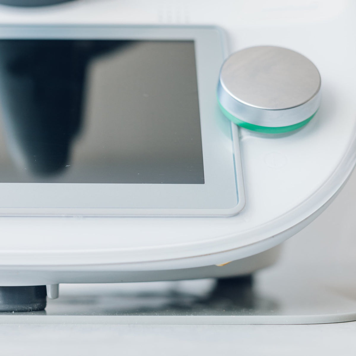 Close-up of a Thermomix base and dial with the Appliance Mat beneath, shown against a light bench