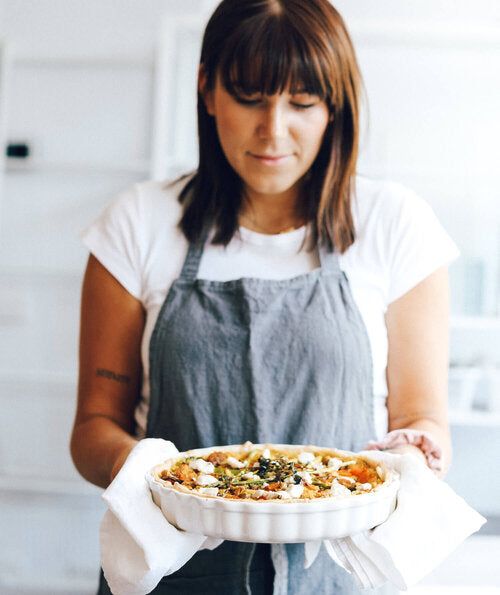 Woman holding a baked tart, made with Black Salt for an eggy flavour