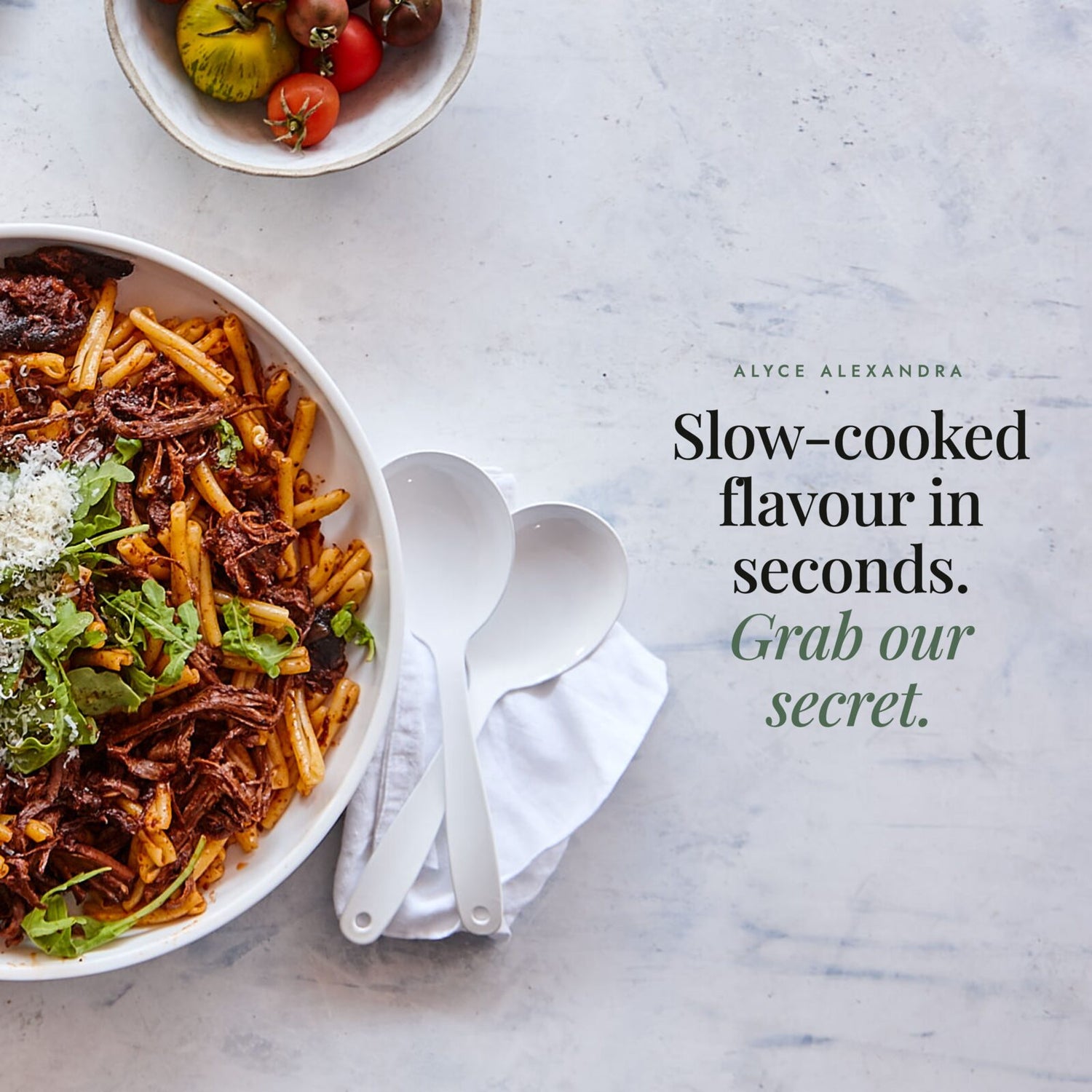 Bowl of pasta with slow-cooked beef ragu, rocket and parmesan beside a bowl of tomatoes; Bolognese Boost Salt gives slow-cooked flavour in seconds