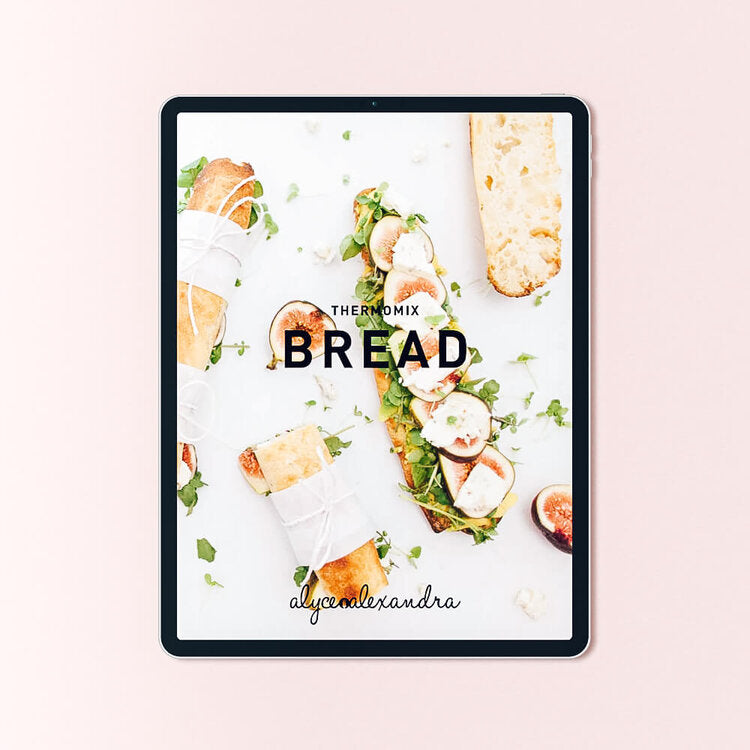 Bread Class Booklet for Thermomix machines shown on a tablet, the cover surrounded by loaves, rolls and filled breads