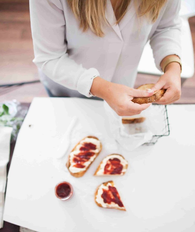 Hands putting together jam-topped bread rolls at a white bench, from the Bread Class Booklet for Thermomix machines