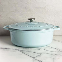 Duck egg blue Chasseur cast iron oval Dutch oven with its lid on, on marble