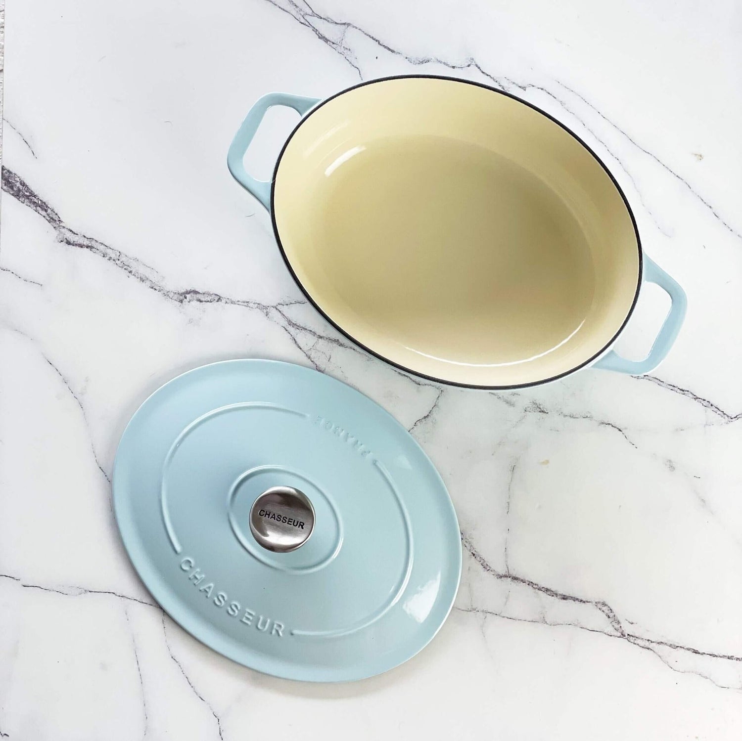 Chasseur cast iron oval Dutch oven with the lid off, showing the cream enamel interior