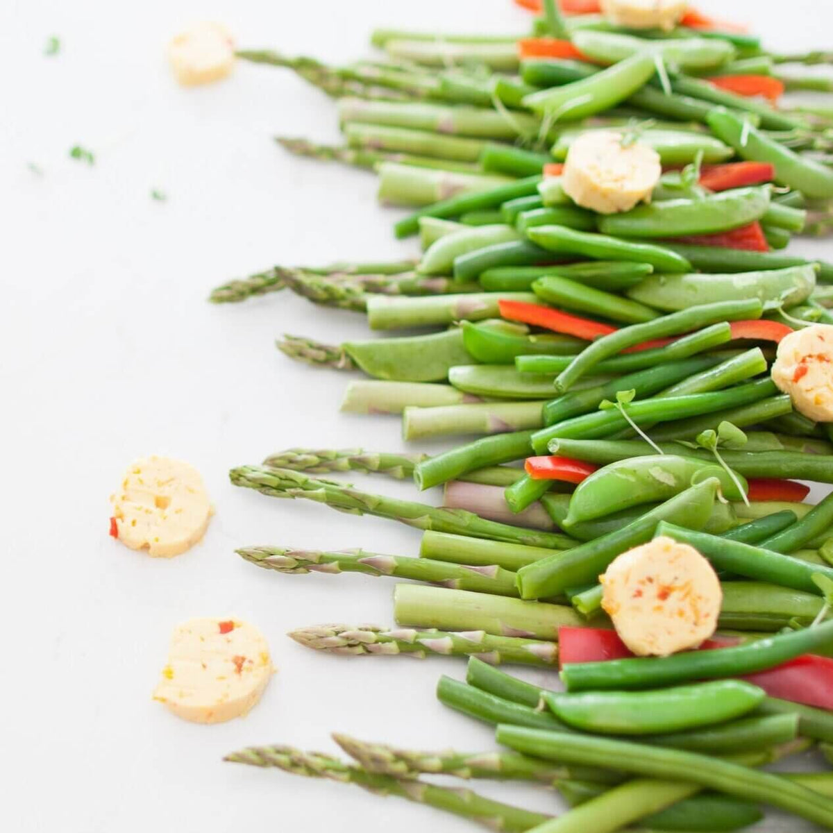 Platter of asparagus, green beans and chilli arranged on a board with roast potatoes alongside, from the Christmas Class Booklet