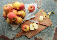 Classic Serrated Knife on a wooden board with sliced and whole apples