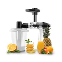 Cold-Pressed Juicer attachment with its collection jug, surrounded by pineapple, oranges and glasses of fresh juice