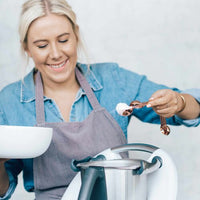 Alyce measuring an ingredient with a Copper Measuring Spoon beside her Thermomix mixing bowl