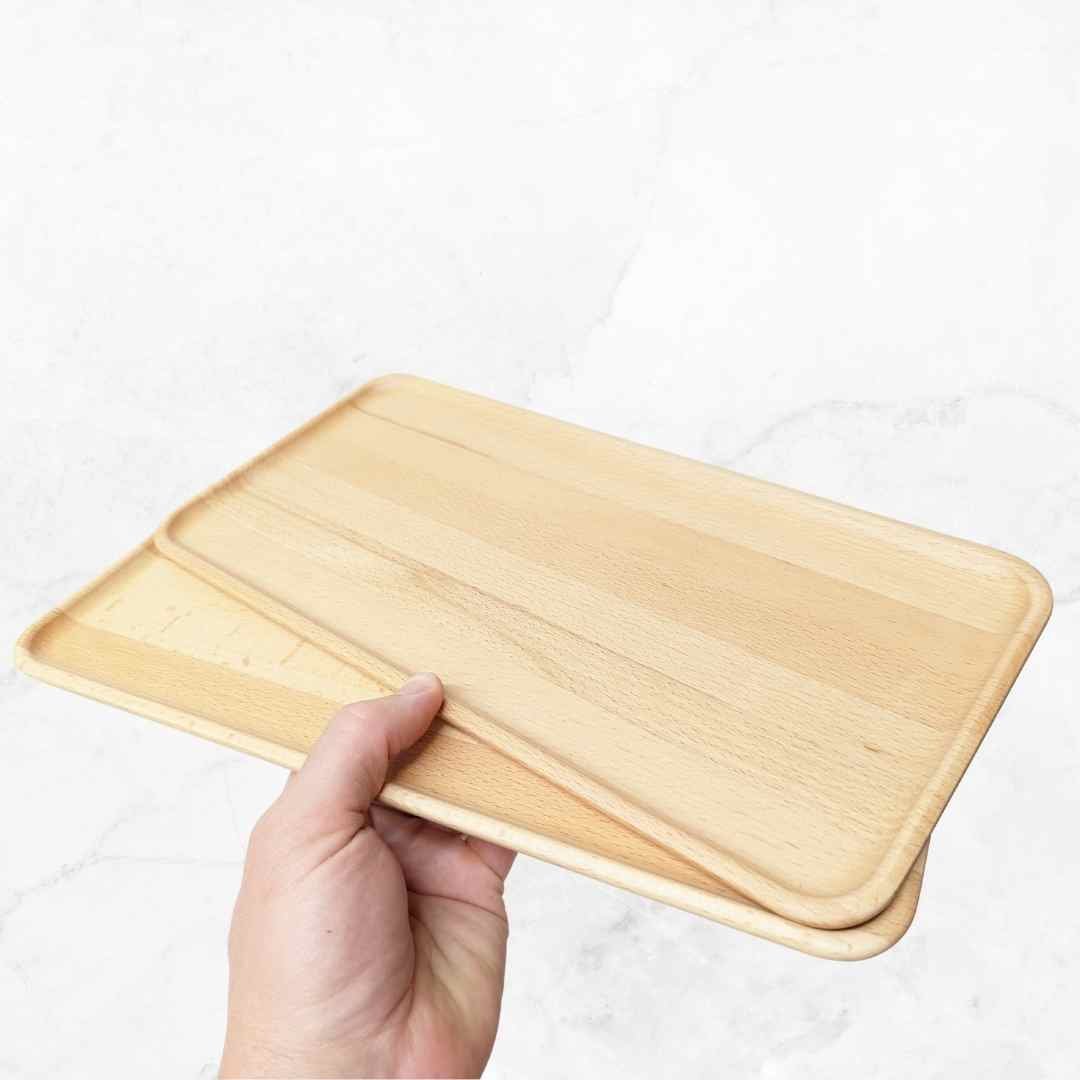 Hand holding the wooden Deluxe Tray to show its rounded corners and smooth finish
