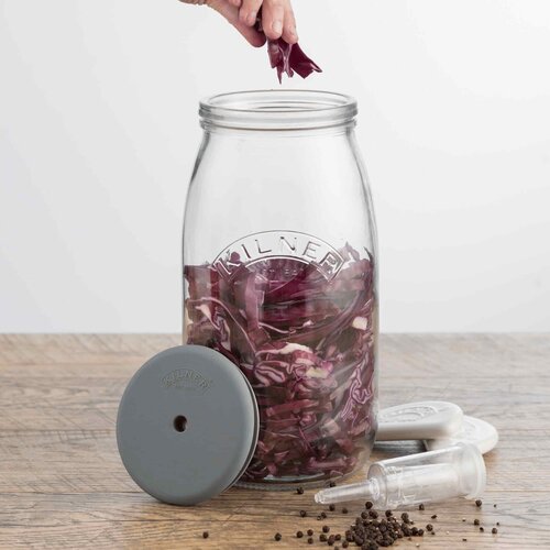 Hand fitting the grey lid onto the Kilner Fermentation Set jar of red cabbage
