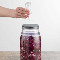 Hand fitting the airlock into the lid of the Fermentation Set jar