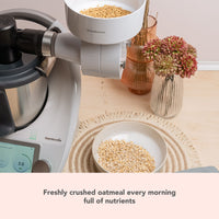 Grain Flaker on a Thermomix beside a bowl of oats; freshly crushed oatmeal every morning, full of nutrients