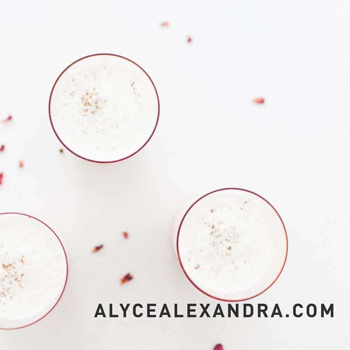 Bowls of Indian dessert topped with rose petals and coconut on a pale surface, from the Indian Class Booklet