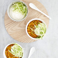 Bowls of soup topped with courgette noodles cut with the Julienne Peeler