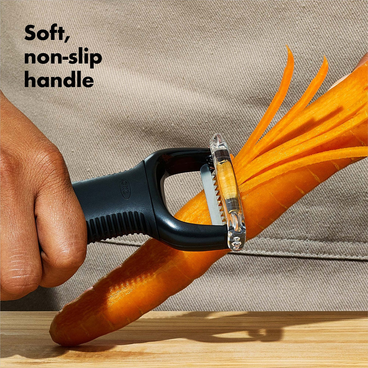 Hand using the Julienne Peeler on a carrot, showing its soft non-slip handle