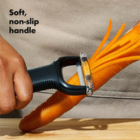 Hand using the Julienne Peeler on a carrot, showing its soft non-slip handle