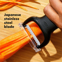 Close-up of the Julienne Peeler cutting a carrot, showing its Japanese stainless steel blade