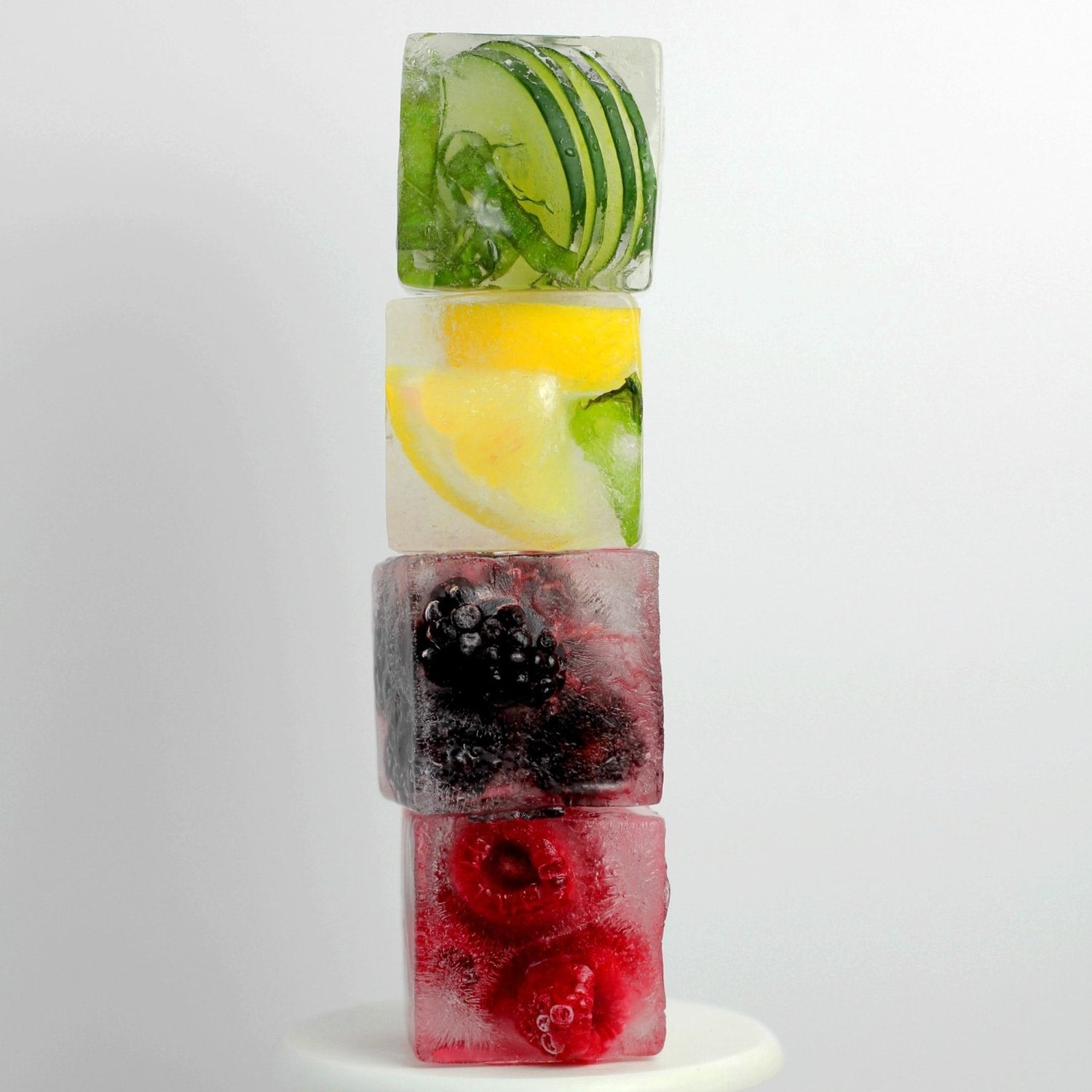 Stacked jumbo ice cubes with lime, lemon and berries frozen inside
