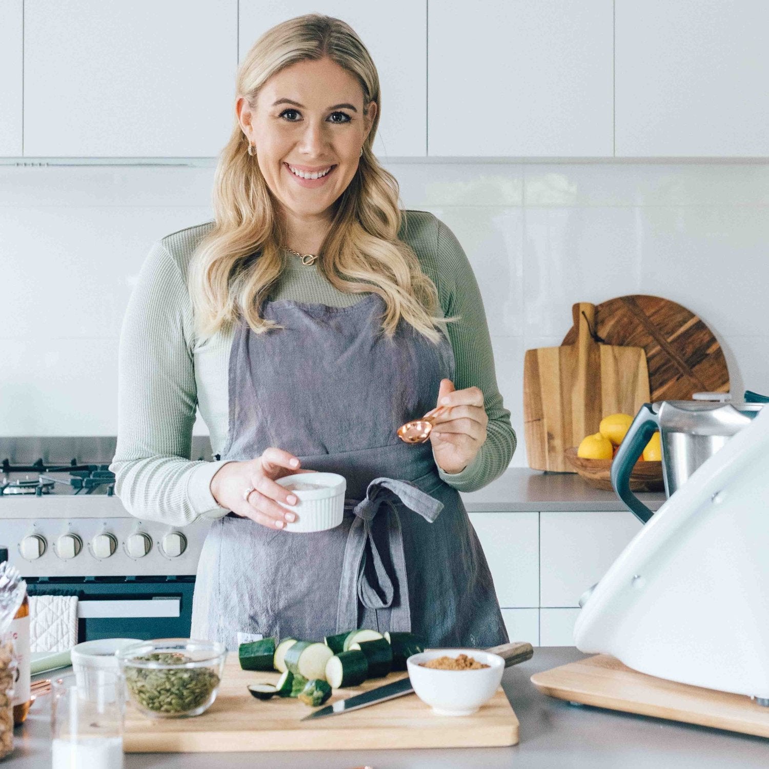 Alyce wearing the charcoal Linen Apron while prepping vegetables beside her Thermomix
