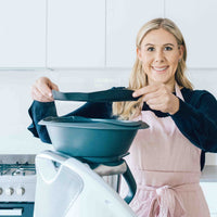 Alyce in a blush pink Linen Apron lifting the Varoma off her Thermomix