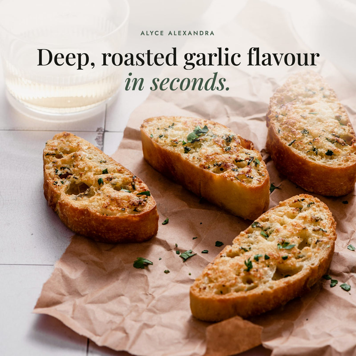 Four slices of golden, crispy garlic bread flecked with fresh parsley on crumpled brown paper; Mighty Garlic Salt gives deep, roasted garlic flavour in seconds