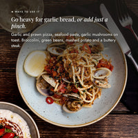 Plate of spaghetti with clams, cherry tomatoes, chilli and toasted crumbs; go heavy with Mighty Garlic Salt for garlic bread or add just a pinch, on garlic and prawn pizza, seafood pasta, garlic mushrooms on toast, broccolini, green beans, mashed potato and a buttery steak