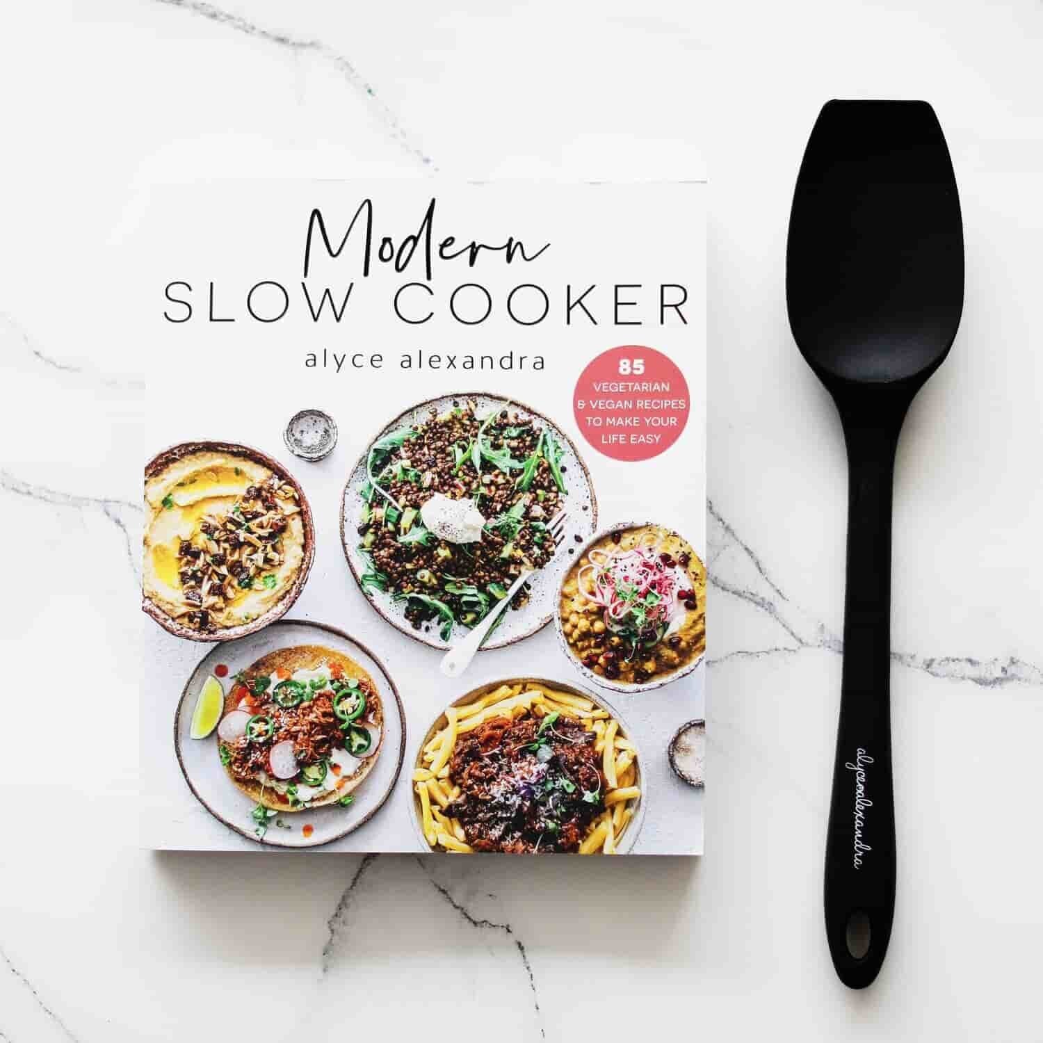Modern Slow Cooker cookbook beside the black Slow Cooker Spatula included in the bundle