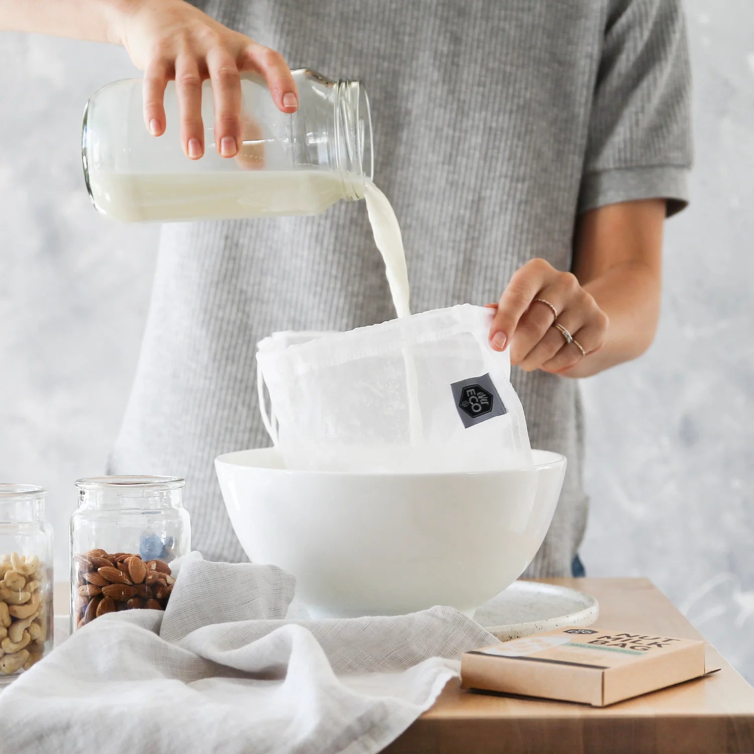 Straining fresh nut milk through the nut milk bag