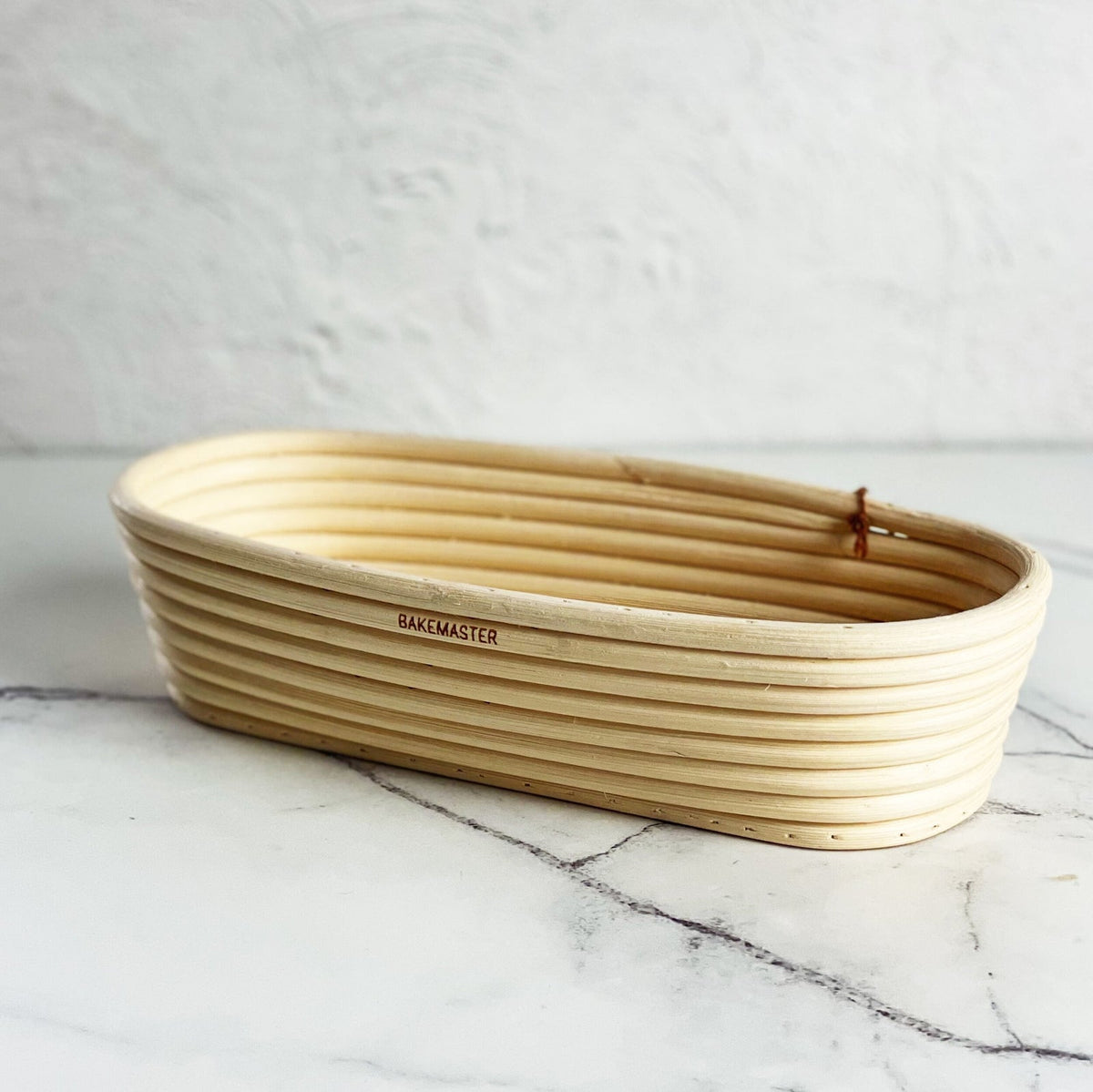 Empty oval rattan proving basket showing its spiral coil pattern