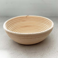 Round rattan proving basket shown from a low angle