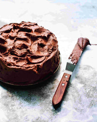 Chocolate frosted layer cake with a palette knife, baked using the Reusable Round Cake Tin Liner