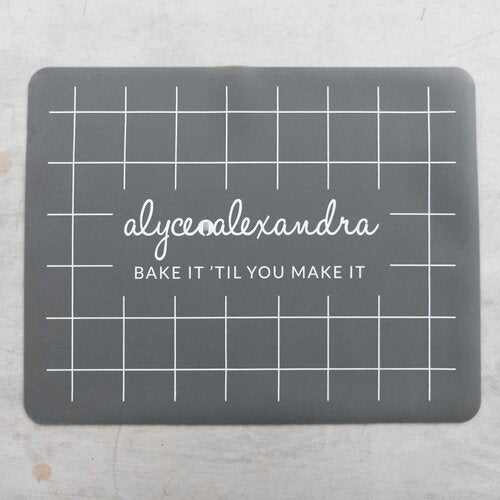Grey Silicone Baking Mat laid flat on a bench, showing the grid and branding