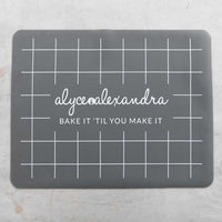 Grey Silicone Baking Mat laid flat on a bench, showing the grid and branding