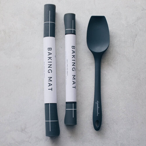 Two rolled Silicone Baking Mats in their tubes beside a dark spatula