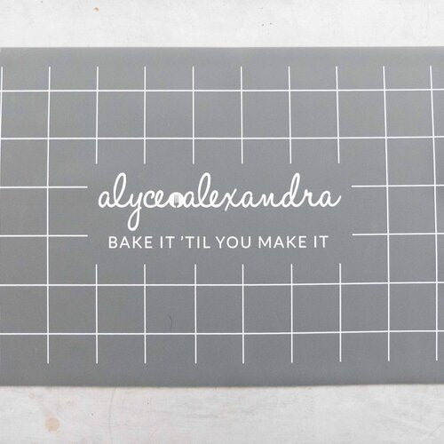 Close-up of the grey Silicone Baking Mat showing the bake it 'til you make it print and grid lines