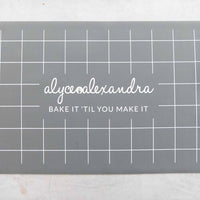 Close-up of the grey Silicone Baking Mat showing the bake it 'til you make it print and grid lines
