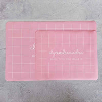 Two pink Silicone Baking Mats in different sizes overlapping on a bench