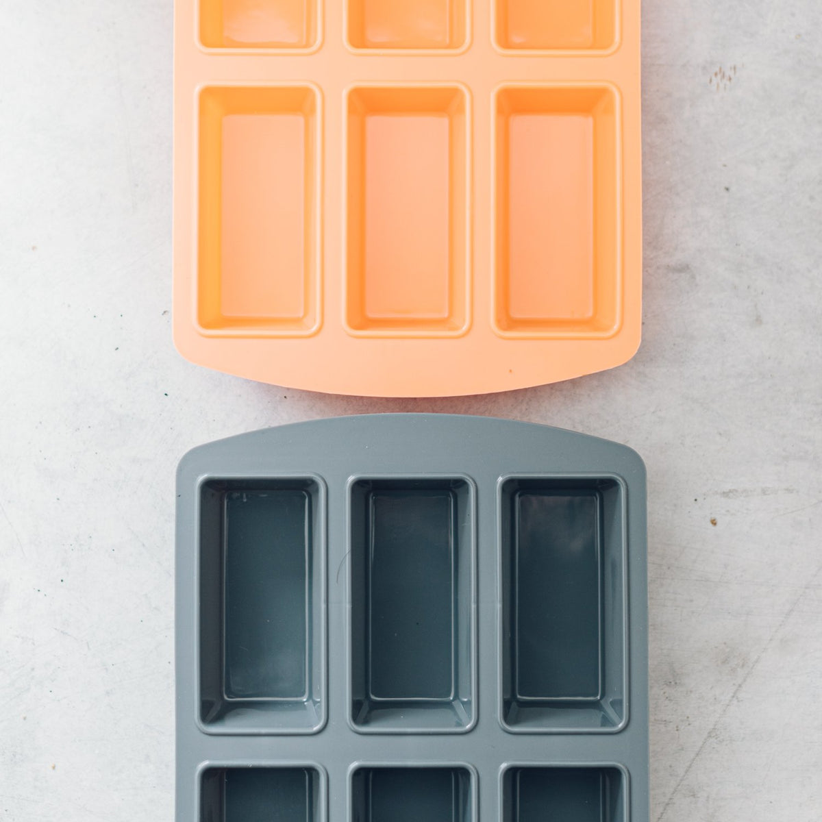 Terracotta and grey Silicone Bar Moulds trays overlapping to show both colours