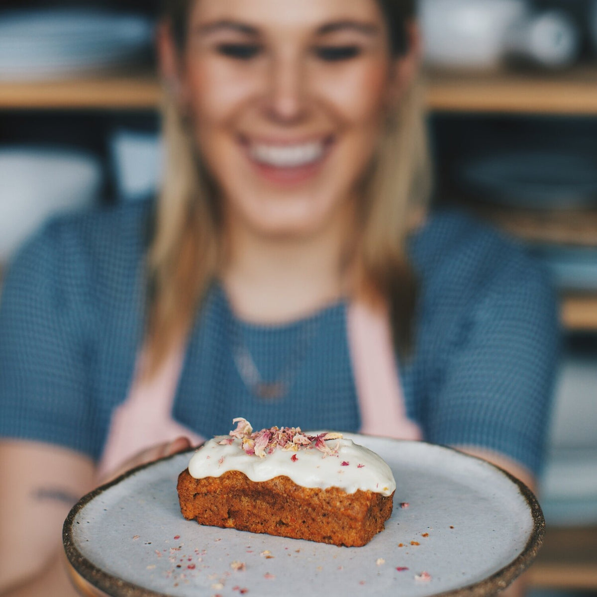 Alyce holding a plate with an iced mini loaf made in the Silicone Bar Moulds